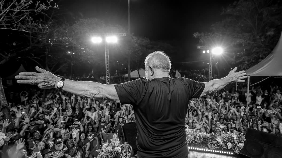Lula de costas, de braços abertos para a multidão num ato de campanha em Ipatinga (MG), em 2022.
